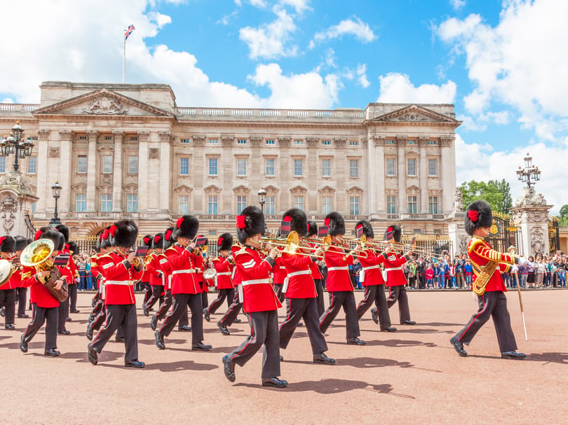 Guards in red tunics and bearskin hats during the Changing of the Guard outside Buckingham Palace